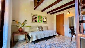 a bedroom with a bed and a table with a plant at Canto do Jão in Paraty