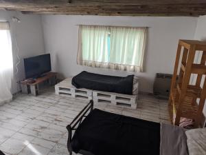een kamer met 2 bedden en een televisie. bij Casa Lidia in Chascomús