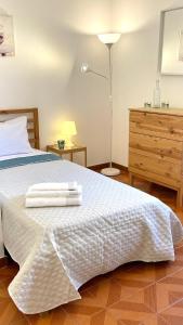 1 dormitorio con 1 cama blanca con lámpara y vestidor en Dal Cavaliere, en Cagliari