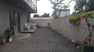 a courtyard of a house with a brick wall at Casa /praia canto grande in Bombinhas