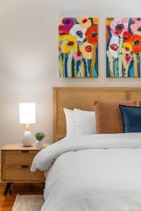 une chambre avec un lit et deux tableaux au mur dans l'établissement Waratah Cottage 1910 - Boutique, à Glenunga