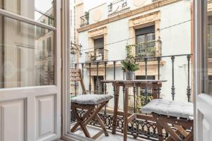 Un balcón con una mesa y sillas y un edificio. en Luxurious apartment in center with parking by REMS, en Málaga