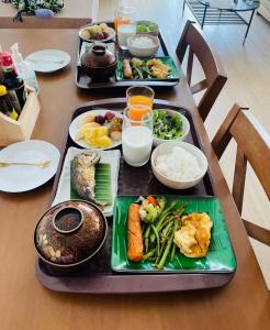 una mesa con tres bandejas de comida. en Yunoya Riverside Villa, en Samut Songkhram