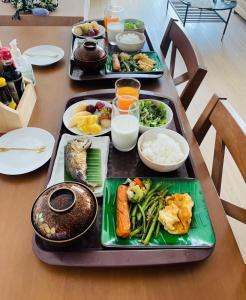 a table with three trays of food on it at Yunoya Riverside Villa in Samut Songkhram