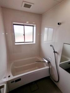 a bathroom with a bath tub and a window at Takachiho B&B Ukigumo in Takachiho