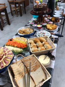 una tavola piena di diversi tipi di pane e prodotti da forno di Do Parque Pousada Comfort a Penha