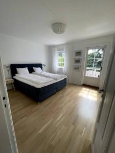 1 dormitorio con 1 cama y suelo de madera en Beach House Ängelholm, en Ängelholm