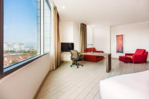 een hotelkamer met een bed, een bureau en een raam bij Hilton Garden Inn Barranquilla in Barranquilla