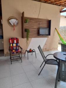 a patio with chairs and a table and a tv at Hospedaria Temporarte in Piranhas