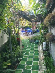 einen Garten mit einer Pergola und grünen Fliesen in der Unterkunft Tasek Homestay D Village Ipoh in Ipoh