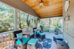 a screened porch with chairs and a ceiling fan at The Harbour Home in Saint Augustine