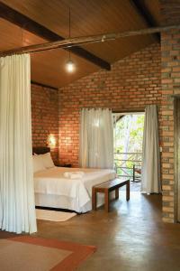 a bedroom with a bed and a brick wall at Rancho das Estrelas in Carolina