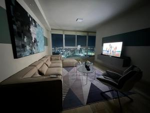 uma sala de estar com um sofá e uma televisão em Penhouse vista al mar y ciudad na Cidade do Panamá