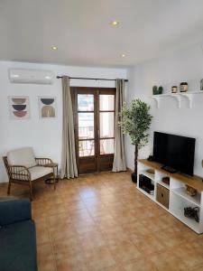 a living room with a couch and a television at Santo Cristo 11 in Frigiliana