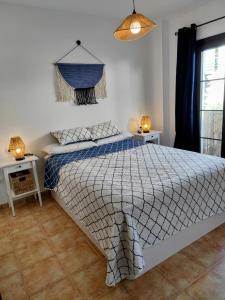 a bedroom with a bed with a blue and white comforter at Santo Cristo 11 in Frigiliana