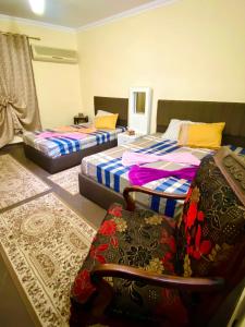 Zimmer mit 3 Betten, einem Stuhl und einem Sofa in der Unterkunft Momen Pyramids Inn in Kairo