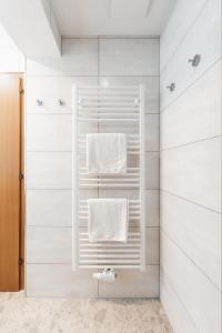 a bathroom with a shower with white towels at Alpenzeit Zillertal Apartments in Zell am Ziller