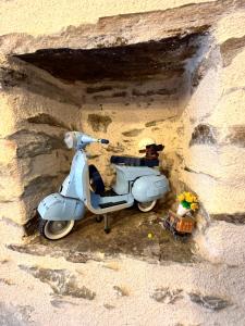 a blue scooter parked in a stone wall at Maison pour 5 personnes proche aéroport de Nantes in Saint-Aignan-Grand-Lieu