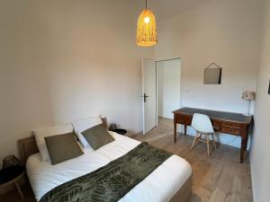 a bedroom with a bed and a desk and a table at Maison pour 5 personnes proche aéroport de Nantes in Saint-Aignan-Grand-Lieu