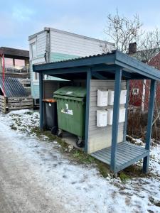 a smallshed with a trash can and a green trashbin at Fresh apartment near everything ! in Tromsø