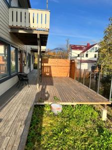 a wooden deck with a bench on a house at Fresh apartment near everything ! in Tromsø