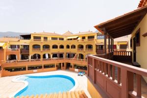 - un grand bâtiment avec une piscine en face dans l'établissement EDEN RENTALS Elite Palace Suites, à Adeje
