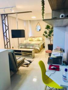 1 dormitorio con 1 cama y escritorio con ordenador portátil en Mi casa Su Casa Apartment Studio 1 a 4 pessoas en Curitiba