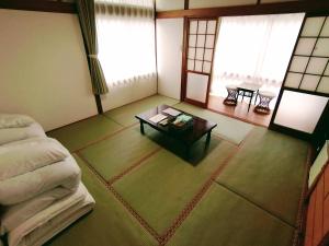 Habitación con cama y mesa de centro. en Takachiho B&B Ukigumo, en Takachiho