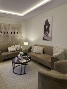 ein Wohnzimmer mit 2 Sofas und einem Couchtisch in der Unterkunft غرفة وصالة بحي الربيع in Riad
