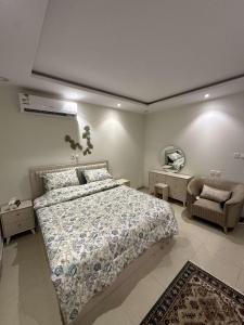 ein Schlafzimmer mit einem großen Bett und einem Stuhl in der Unterkunft غرفة وصالة بحي الربيع in Riad