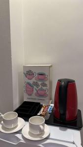 einen Wasserkocher und zwei Tassen auf einem Tisch mit einer Schachtel in der Unterkunft غرفة وصالة بحي الربيع in Riad