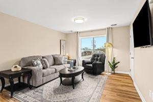 a living room with a couch and a table at New! Modern Upper Flat near Downtown Roseville in Roseville