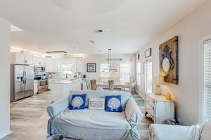 a living room with a couch and a kitchen at Serenity Now in Santa Rosa Beach