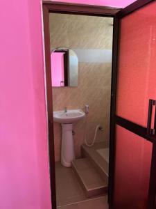 a bathroom with a sink and a toilet and a mirror at Kilimanjaro Smiley Inn in Moshi +10 photos