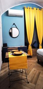 sala de estar con mesa y cortinas amarillas en Trebis, en Nápoles