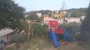 a playground with a slide in a yard at Anka Studios in Vrbnik