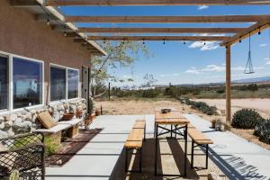 a patio with benches and tables on a building at Desert Home Private Oasis Outdoor Space & Hot Tub in Yucca Valley