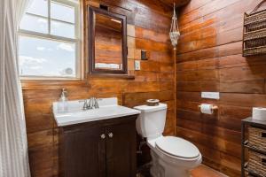 a bathroom with a toilet and a sink and a window at Desert Home Private Oasis Outdoor Space & Hot Tub in Yucca Valley +39 photos