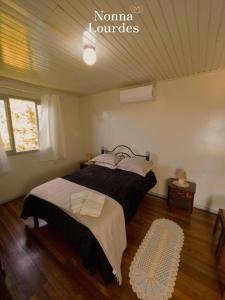 ein Schlafzimmer mit einem großen Bett in einem Zimmer in der Unterkunft Recanto Nonna Lourdes - Vale dos Vinhedos in Bento Gonçalves