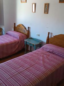 una habitación con 2 camas y una mesa azul entre ellas en El Balcón Del Jucar, en Alcalá del Júcar