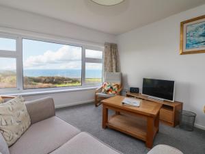a living room with a couch and a large window at The Barn in Gunwalloe