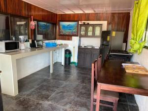 a kitchen with a table and a kitchen with a refrigerator at Family-sized Beach Suite in Playa Matapalo in Savegre