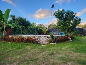 a retaining wall with flowers and a fence at Cabañas VILLA PAOLA in Rivera