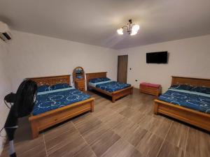 a room with three beds and a flat screen tv at Cabañas VILLA PAOLA in Rivera