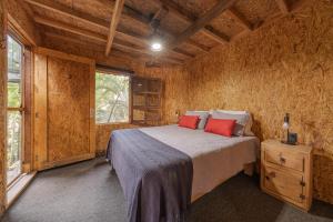 a bedroom with a bed in a wooden cabin at El Refugio de Sayulita - Health and Wellness House in Sayulita