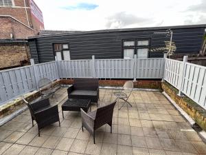 a patio with chairs and tables and a fence at Flat in central London with large patio in London