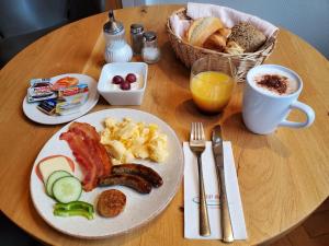 ein Tisch mit einem Teller Frühstücksessen darauf in der Unterkunft TRIP INN PostHotel Düren in Düren - Eifel