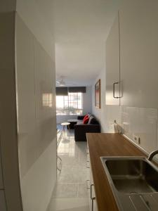 a kitchen with a sink and a living room at Apartamento moderno y familiar Live Santa Cruz Centro in Santa Cruz de Tenerife