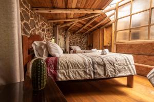 a bedroom with a bed and a large window at Bungalow RURU WASI in Urubamba