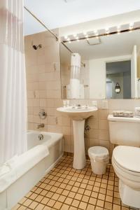 uma casa de banho com um lavatório, uma banheira e um WC. em Rosellen Suites at Stanley Park em Vancouver